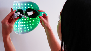 Model placing on Mirabella 7-Color LED Mask: featuring Green light, see-through goggles, adjustable nose piece, and ear piece.
