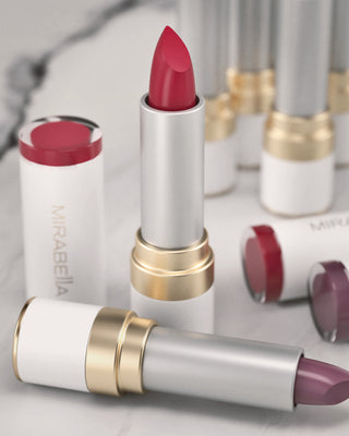 Mirabella Sealed with a Kiss Lipsticks in Perfect Red and Sugar & Spice, creamy fall shades with luxe white and gold tubes on marble background.