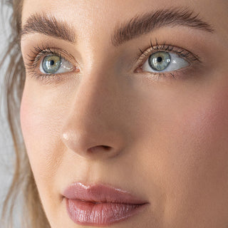 Close-up beauty portrait of a model with softly defined, natural-looking brows and glowing skin for Mirabella Beauty’s September brow essentials promotion.
