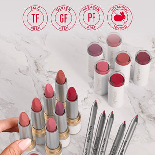 Mirabella lip collection featuring lipsticks, tinted lip balms, and lip definers in a variety of flattering shades on a marble vanity.