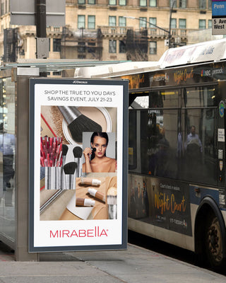 Street-side bus stop display showing Mirabella’s ‘TRUE TO YOU DAYS’ savings event, July 21–23. The poster features a collage of Mirabella makeup.