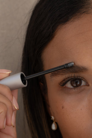 Model applying Mirabella Pro Sculpt Clear Brow Gel for naturally shaped and defined brows