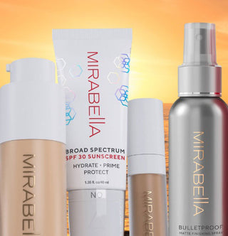 Mirabella Beauty's SPF Primer, Invincible Foundation, Invincible Concealer, and Bulletproof Matte Setting Spray shown against a glowing sunset backdrop, highlighting long-wear summer makeup essentials.