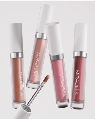 Four Mirabella lip gloss tubes in shimmering nude and pink shades with applicator, featured in The Lip Edit 30% off lip promotion.