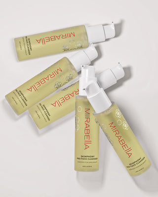 Multiple Mirabella Skinphony Pro Face Cleanser bottles arranged in flat lay on neutral background showing packaging and pump design