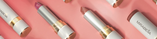 Flat lay of Mirabella Sealed With a Kiss Soft Satin lipsticks in Pink Quartz and Sheer Perfection displayed on pink satin background.